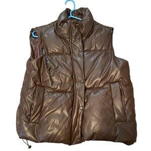 Puffy Brown Zipper jacket that is sleeveless.